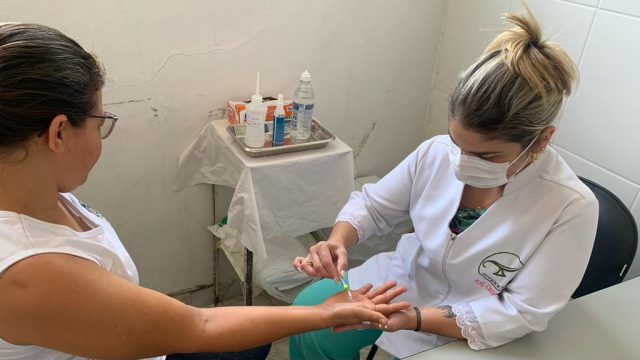 Enfermeira Cíntia Moreira aplicando a avaliação neurológica simplificada em pessoa que teve contato com hanseníase 